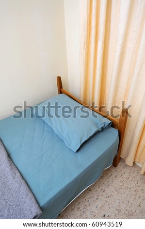 Single bed in motel room for generic concepts. Suitable for concepts such as budget travel, tourism, vacation and holiday, and relaxation.