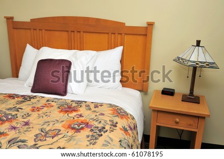 Single bed in luxurious hotel room with side table. Suitable for concepts such as travel, tourism, vacation and holiday, and relaxation.