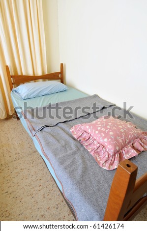 Single bed in clean and simple room. Suitable for concepts such as budget travel, tourism, vacation and holiday, and relaxation.