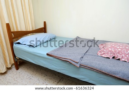 Single bed in clean and simple motel room. Suitable for concepts such as budget travel, tourism, vacation and holiday, and relaxation.