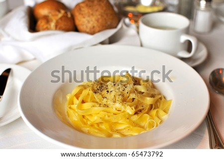 Tasty Italian style fettuccine cooked in cream sauce with luxurious table layout.