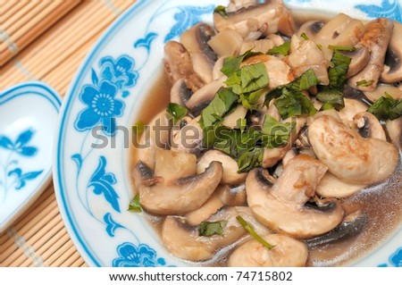 Closeup shot of Oriental style cooked brown mushrooms in gravy.