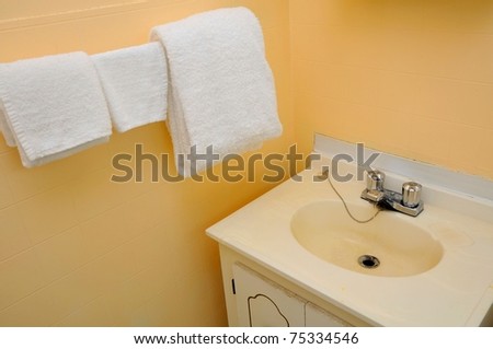 Wash up area in hotel with wash basin and clean towels.