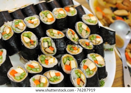 Rows of Japanese vegetarian sushi with vegetable and egg ingredients.