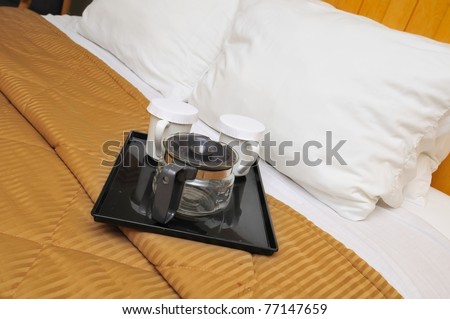 Coffee maker and drink utensils on soft and comfortable bed.