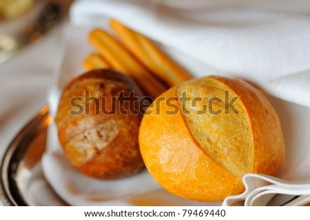 Macro shot of single french loaf with other variety of bread.