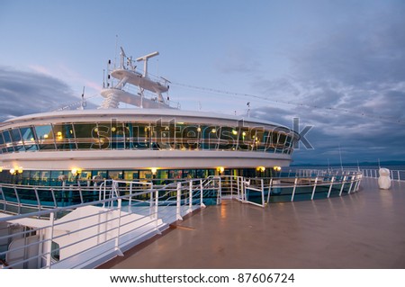 View of front deck of cruise ship sailing during sunset.