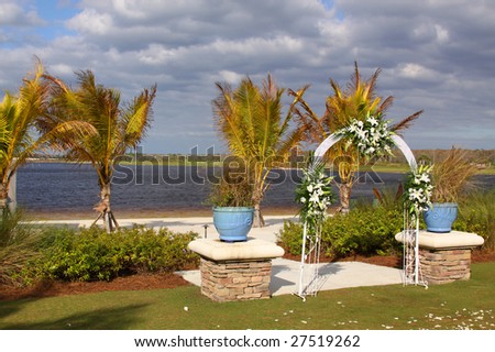 stock photo Wedding arch decorated with flowers in front of the palms and