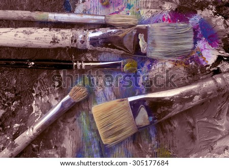 Art brushes on the palette with a palette knife