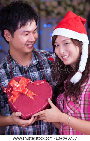 young asian girl and boyfriend with a present box at christmas