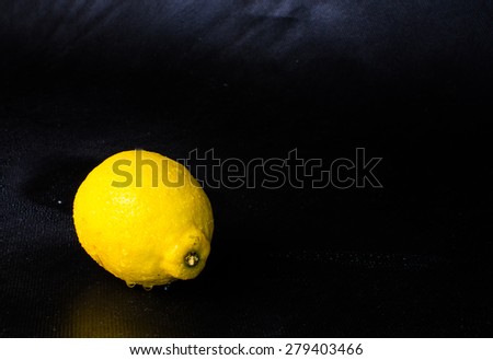 Studio shot of single lemon isolated on black background