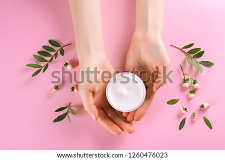Moisturizing care skincare face cream for healing complicated troubled skin type in an open jar with visible texture. Copy space, close up, background, flat lay, top view. Eucalyptus leaf decoration.