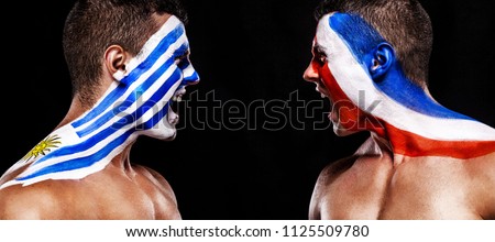 Soccer or football fan with bodyart on face with agression - flags of Uruguay vs France. Sport Concept with copyspace.