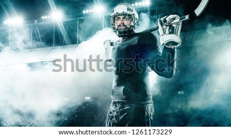 Ice Hockey player in the helmet and gloves on stadium with stick.