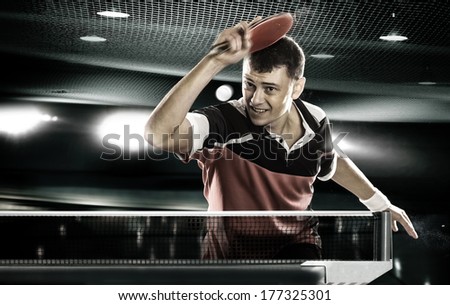 Young Sports Man Tennis-Player In Play On Black Background With Lights