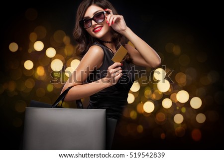 Shopping woman holding grey bag on new year background with lights bokeh in black friday holiday