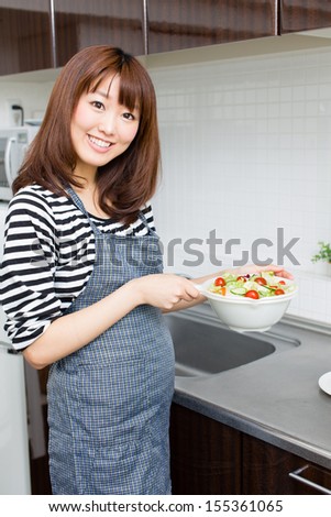attractive asian woman cooking in the kitchen