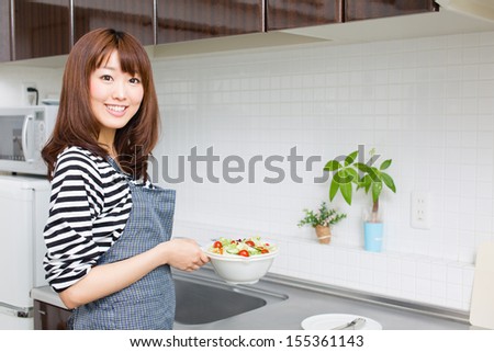 attractive asian woman cooking in the kitchen