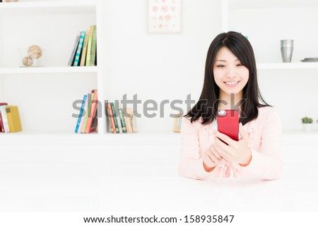 young asian woman using smart phone behind book shelf