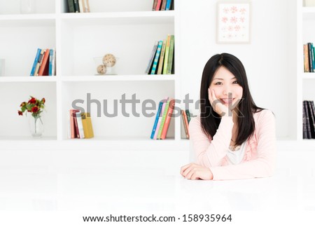 young asian woman relaxing behind book shelf