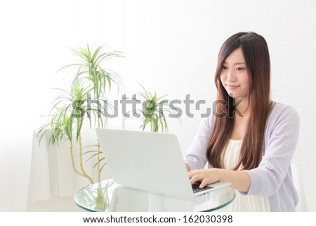 young asian woman using laptop computer in the cafe