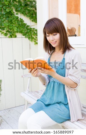 young asian woman reading book in the garden