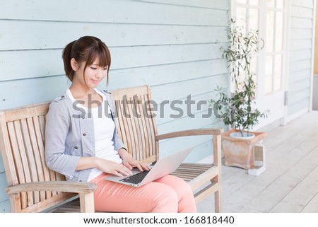young asian woman using laptop computer in the garden
