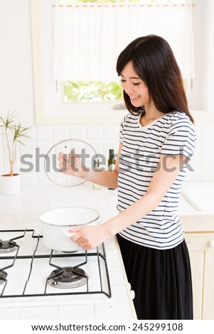 young asian woman cooking in the kitchen