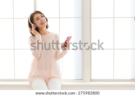 young asian woman listening music