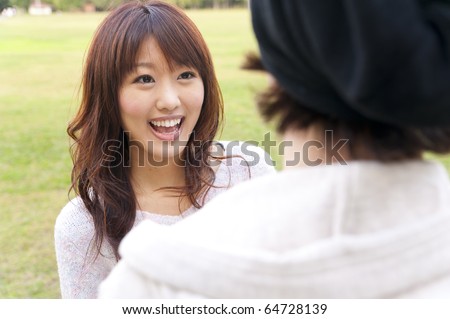 a portrait of young couple looking each other in the park