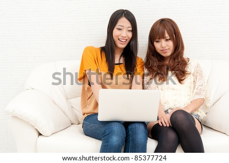two asian women using laptop computer