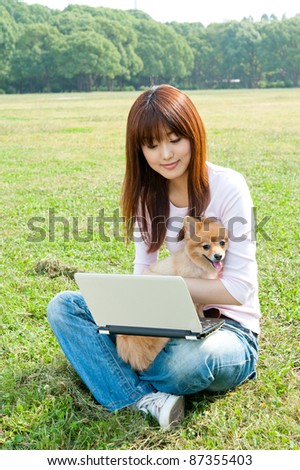 beautiful asian woman using laptop computer with dong in the park