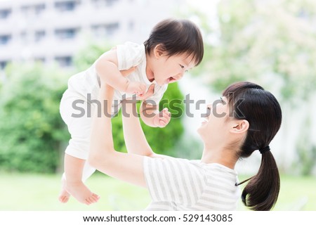 portrait of asian mother and baby relaxing in the garden