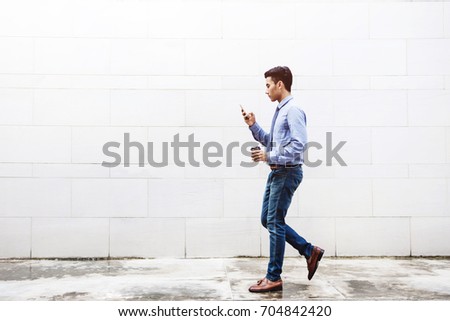 Young motivation Businessman Text or Reading Smart Phone while Walk outdoor building, Lifestyle of modern male, Technology to Communicate in Business concept