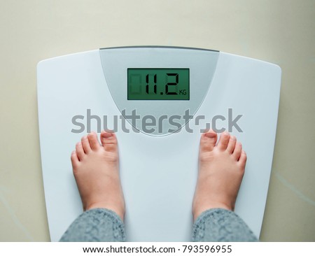Healthy Weight Gain for Baby or Children Concept, A 2 Years Old Kid Standing on Weight Scales, Top View
