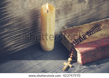 cross, book and candle on wooden background