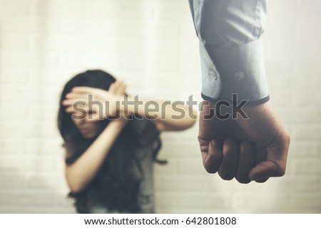 Domestic violence concept with scared and wounded woman protecting from a violent man