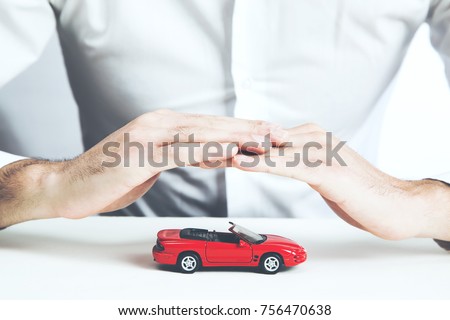 Car insurance concept. Man and model of car  on table