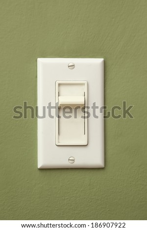 A light switch and a green wall.