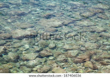 Rocks at the bottom of a clear body of water.