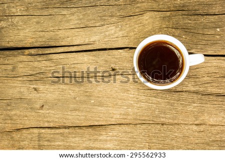 Coffee cup with roasted coffee beans on wooden table. View from top