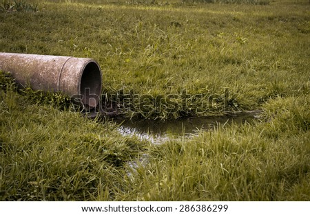 sewer pipe to waste water on the green grass