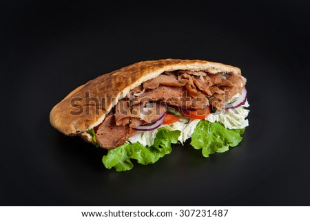 Kebab in pita bread isolated on black background