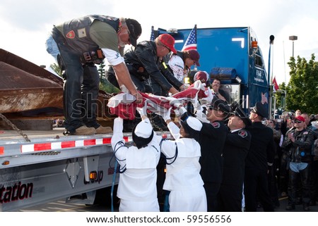 SILVERDALE, WA - AUGUST 22: The flag which accompanied the 9/11 Memorial Steel from New York to Silverdale is handed to local firefighters and Navy personnel for folding August 22, 2010 in Silverdale.