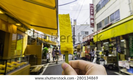Japanese style grill egg roll stick, sold at Tsukiji fish market, shops and store background