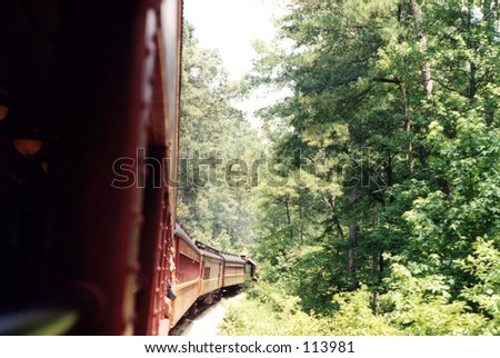 Looking out of a train window, at the length of the train; noticeable perspective.