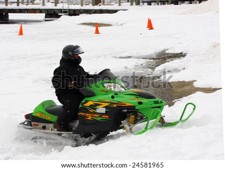 LAKE GEORGE, NY - February 7, 2009: A snowmobile rider exits the ice on Lake George in order to enjoy the  February 7 , 2009 Lake George Winter Carnival.