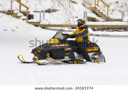 LAKE GEORGE, NY - February 7, 2009: A snowmobile rider exits the ice on Lake George in order to enjoy the  February 7 , 2009 Lake George Winter Carnival.