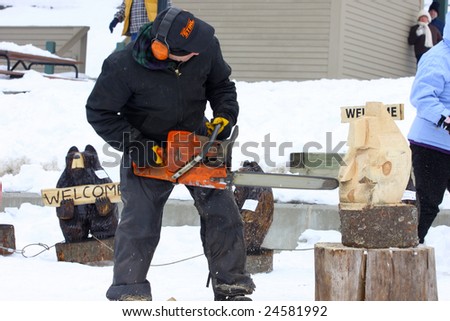 LAKE GEORGE, NY - February 7, 2009: A local artist carves a wooden bear out of a solid block of wood using a chainsaw at the February 7 , 2009 Lake George Winter Carnival.