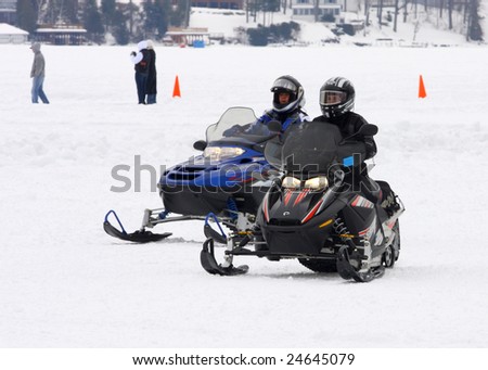 LAKE GEORGE, NY - February 7, 2009: A couple snowmobile riders exit the ice on Lake George in order to enjoy the February 7 , 2009 Lake George Winter Carnival.